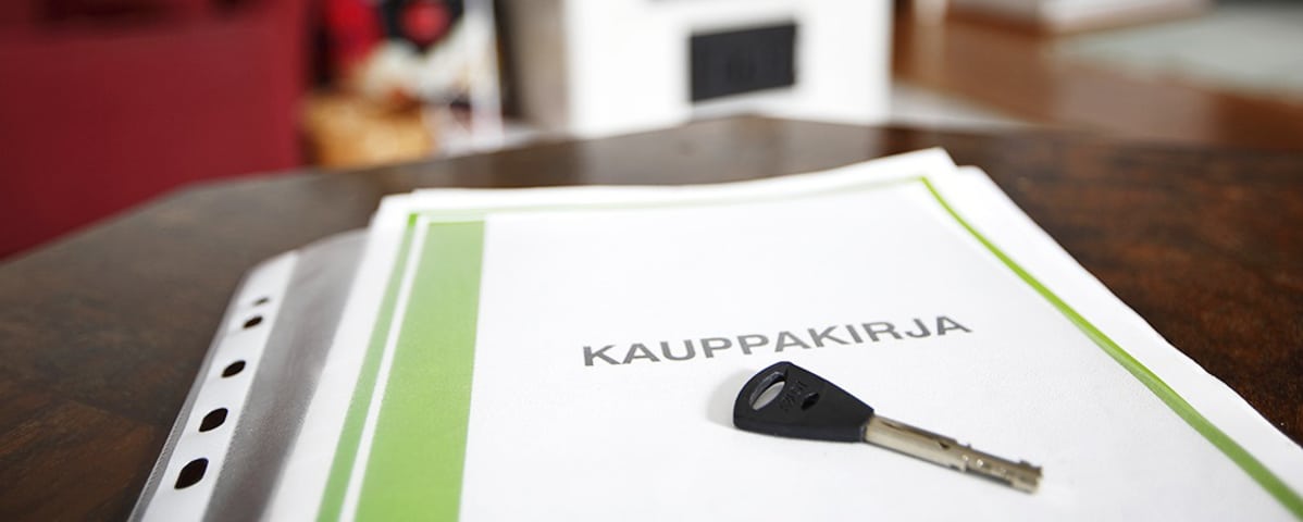Kauppakirja ja avain pöydällä.