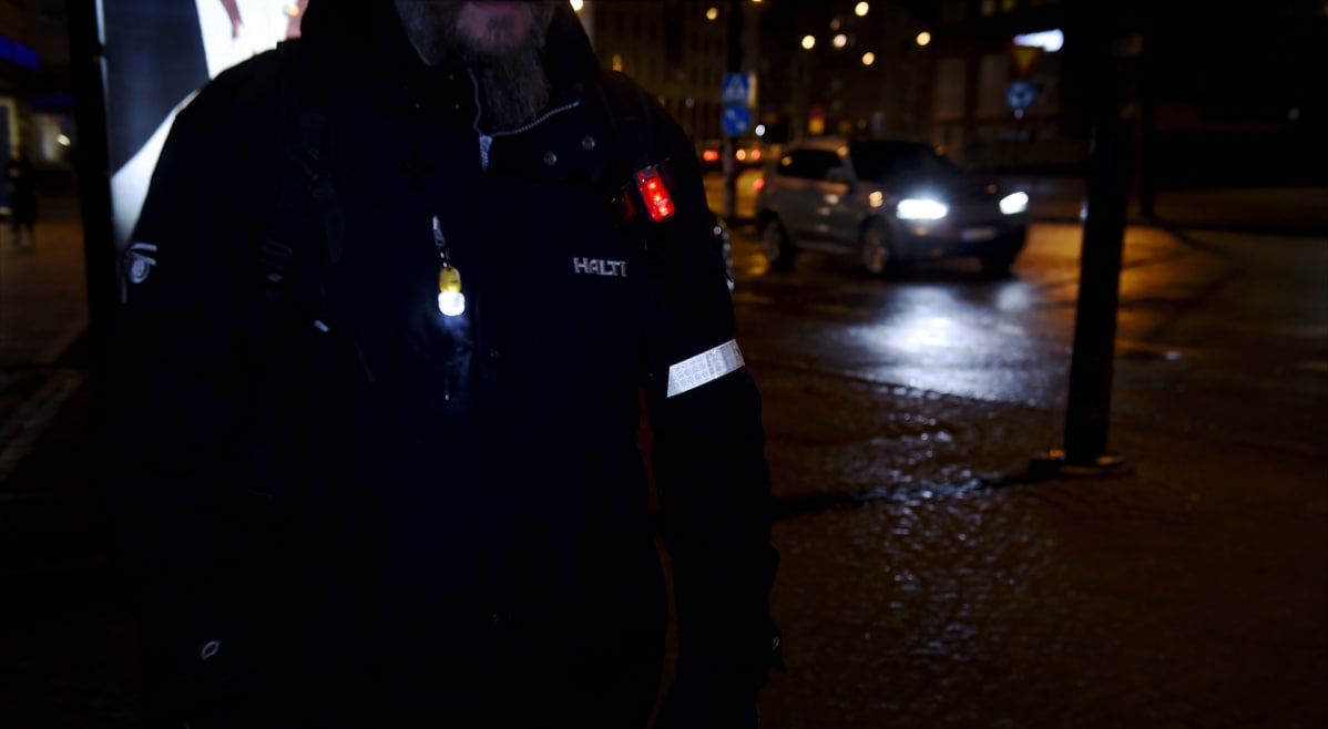 Heijastin ja led-valoja jalankulkijalla.