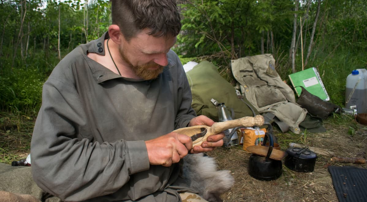 Mies vuolee puunpalasesta kauhaa.
