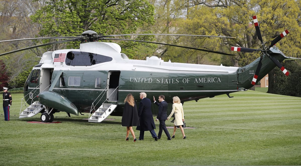 Yhdysvaltain presidentti Donald Trump ja puoliso Melanie Trump sekä Ranskan presidentti Emmanuel Macron ja puoliso Brigitte Macron kävelevät kohti Trumpin helikopteria.