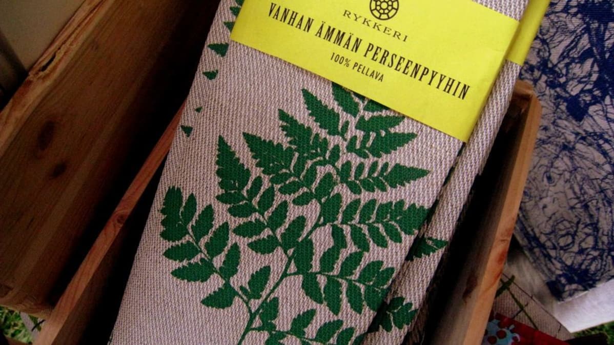 Pellapyyhkeitä taiteltuina joissa teksti Vanhan ämmän perseenpyyhin
