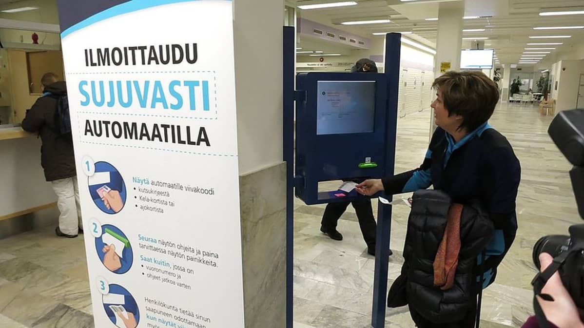 Tunnistautuminen ilmoittautumisautomaattii. Lapin sairaanhoitopiirin valtuuston pj. Merja Mäntyniemi toimii koepotilaana.
