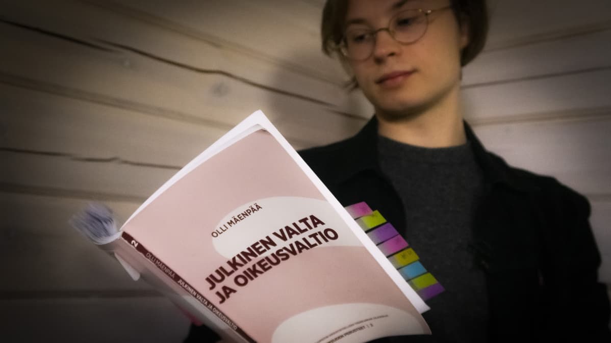 Opiskelija lukee pääsykoekirjaa