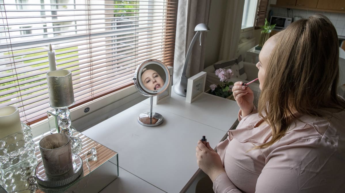 Sandra Kurki meikkipöytänsä ääressä meikkaamassa