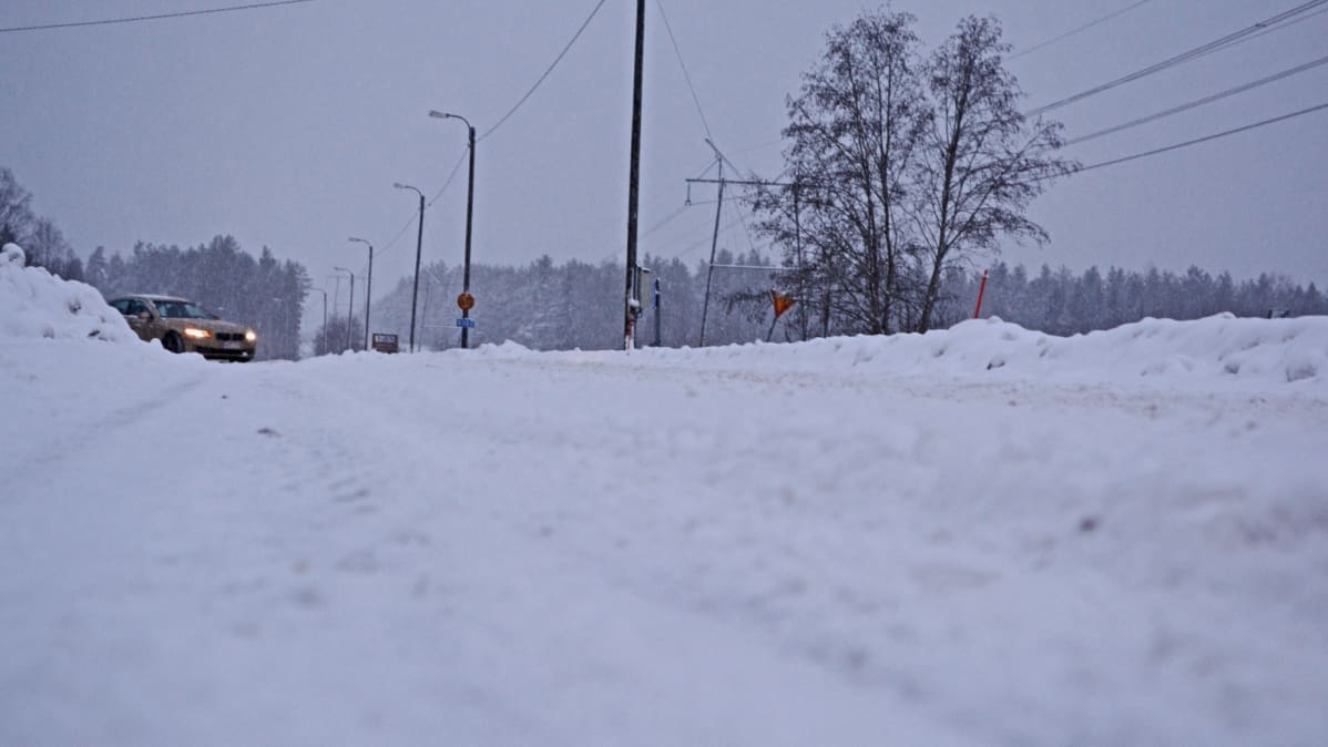Auto kääntyy lumiselle tielle.