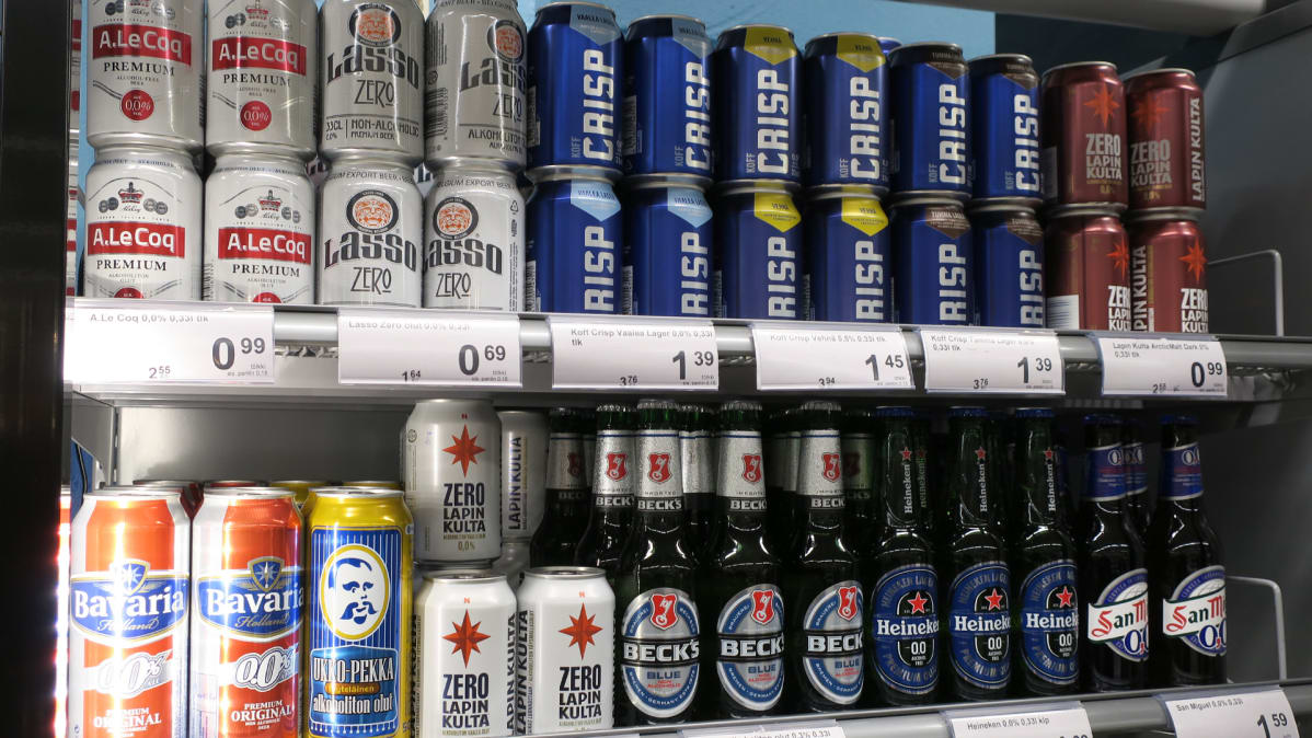 Alkoholittoman oluen tölkkejä ja pulloja kaupan kylmäkaapissa.