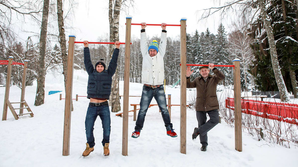 kolme miestä roikkuu rekillä