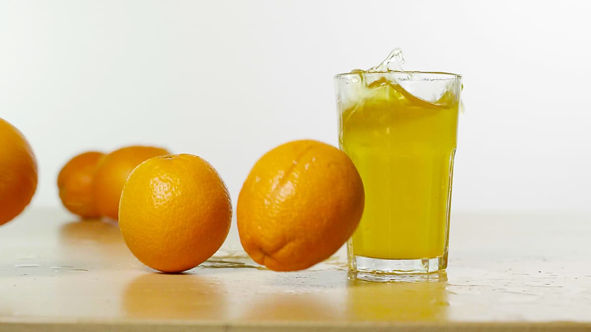 Appelsiineja ja juomalasi pöydällä.