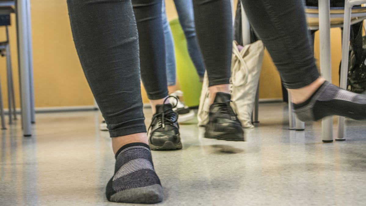 Kuvassa näkyy oppilaiden jalkoja, kun he tekevät taukojumppaa.