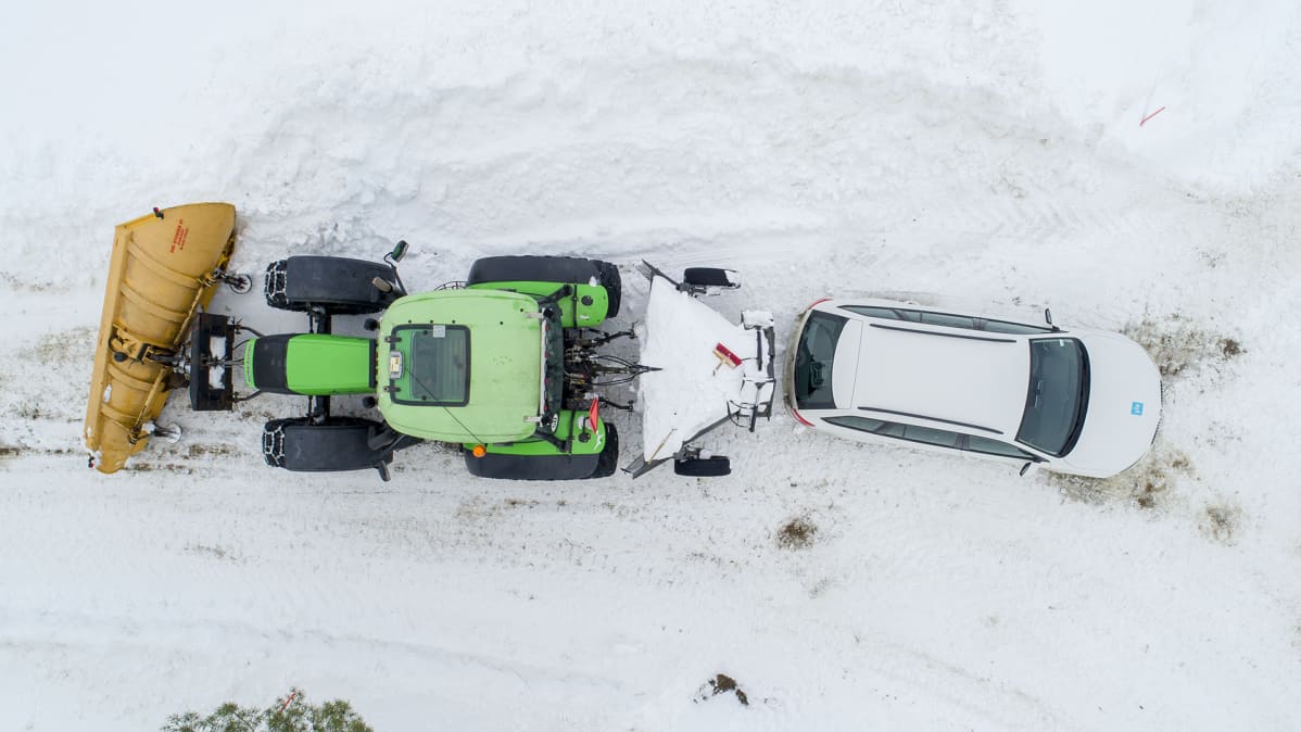 Traktori ja henkilöauto on kuvattu ylhäältä päin.