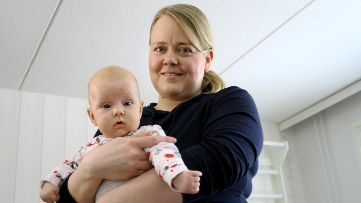 Äiti kuvattuna vauva sylissään.