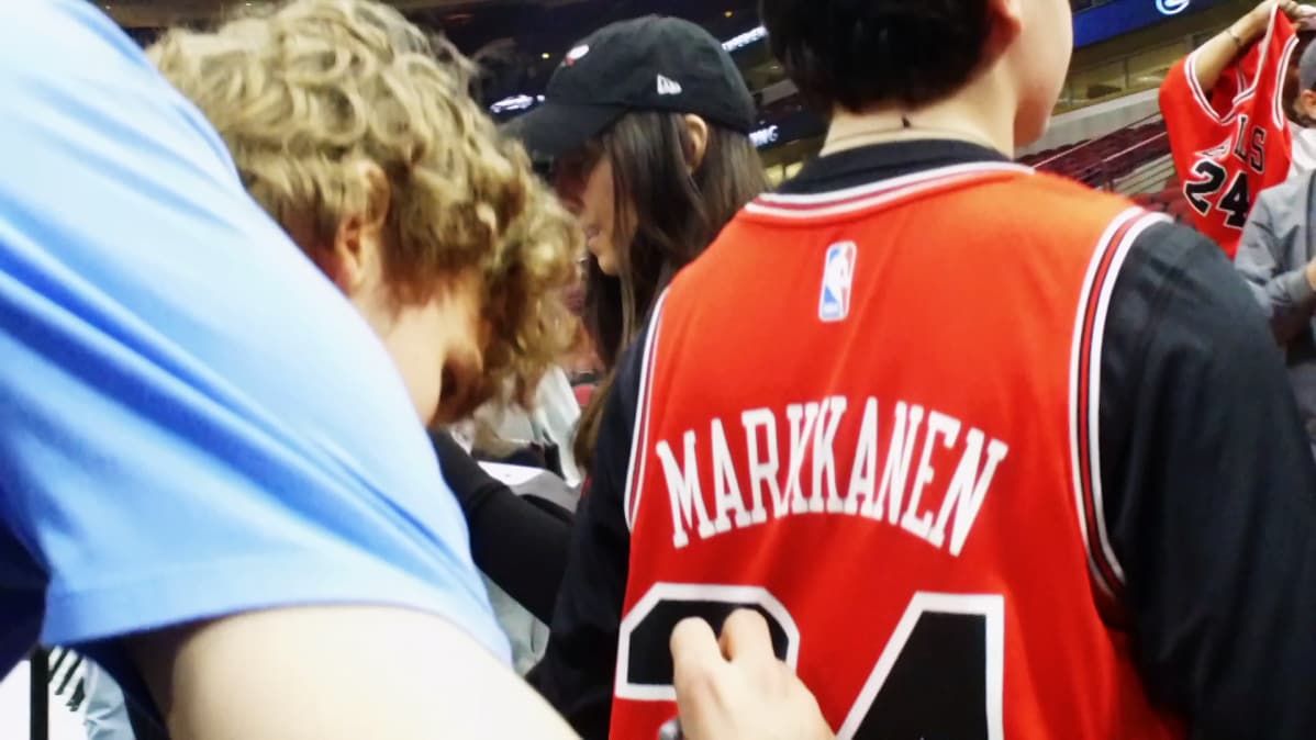 Lauri Markkanen kirjoittaa nimmaria fanin paitaan
