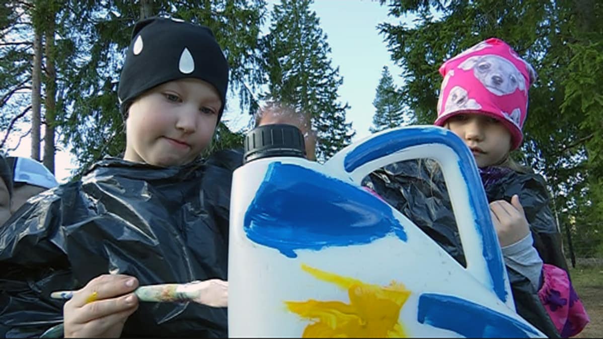 kaksi lasta maalaa muovikanisteria, Koria, Upseerin päiväkoti