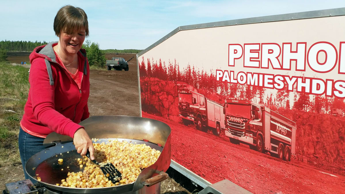 Marianne Ukskoski paistaa pyttipannua turvepalon sammuttajille.