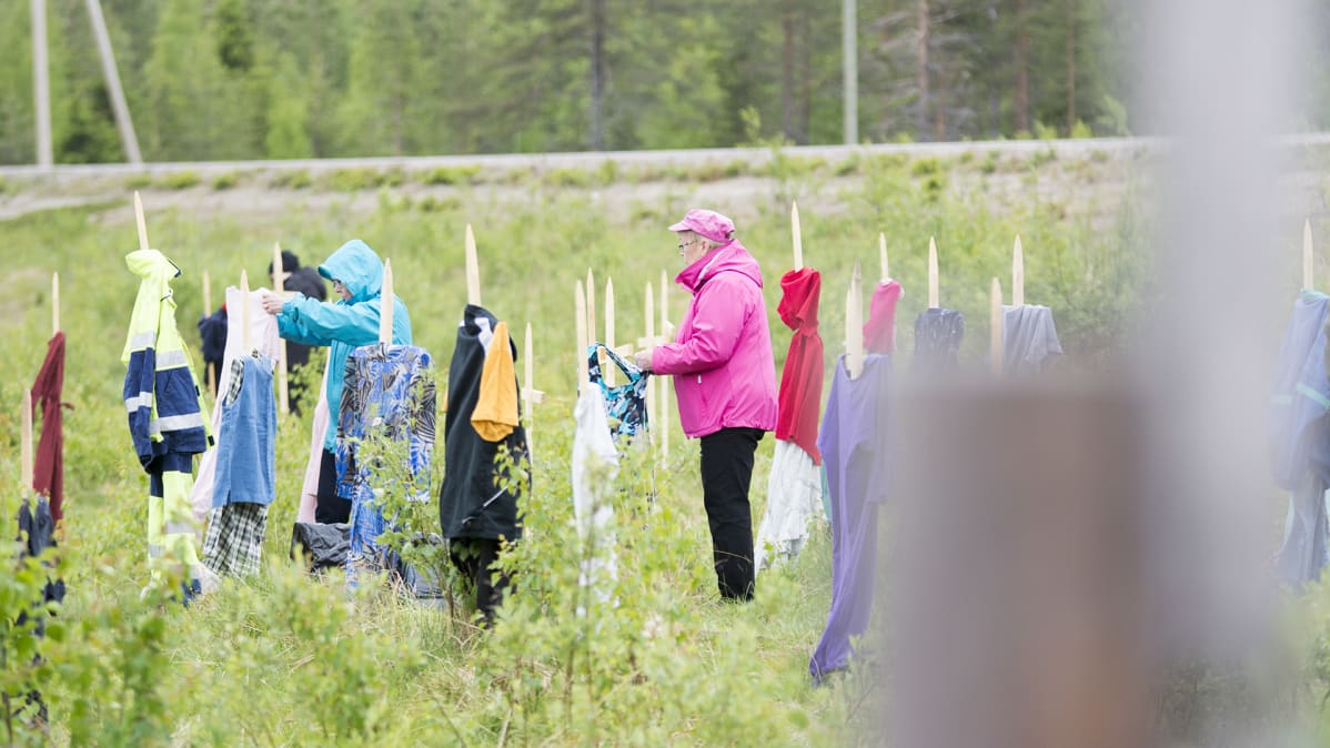 Naiset pukevat linnunpelättimiä.