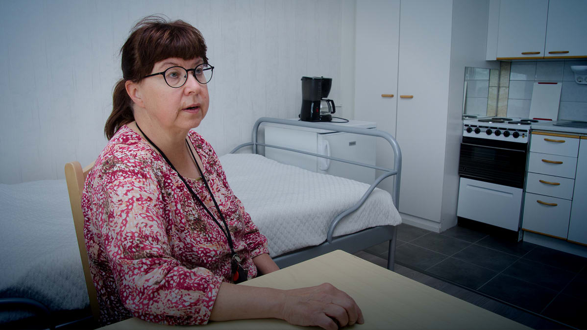 Riitta Mustonen istuu yksiössään.