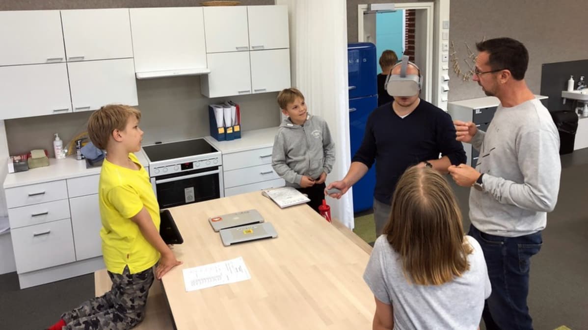 Opettajat ja oppilaat testaavat virtuaalilaseja.