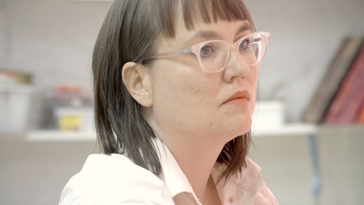 Maaria OIkarinen maalaa keskittyneenä.