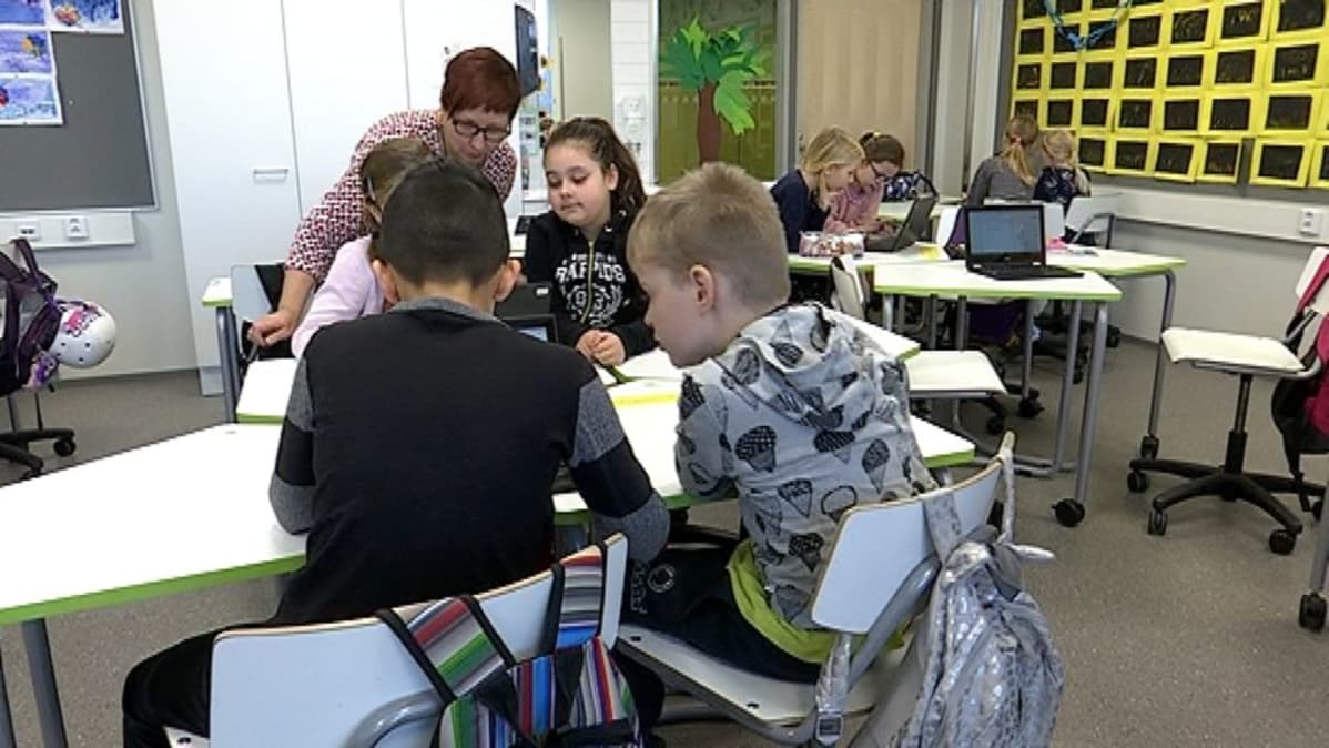 Opettaja ja oppilaita Kaarisillan koulussa