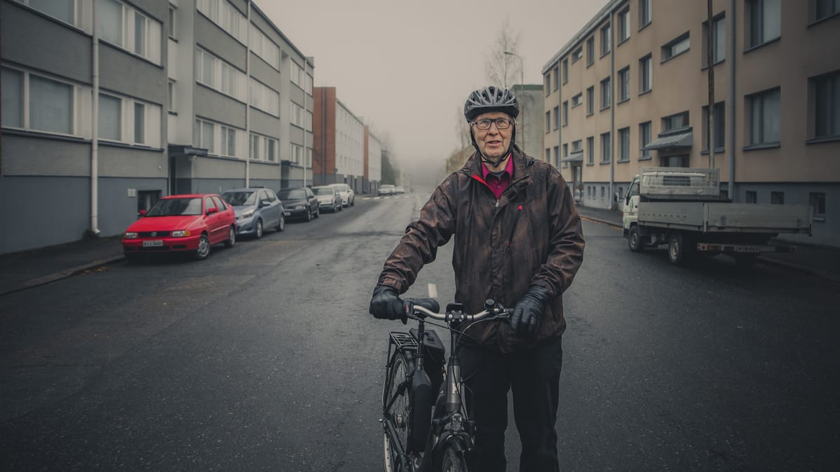Mies pyöränsä kanssa