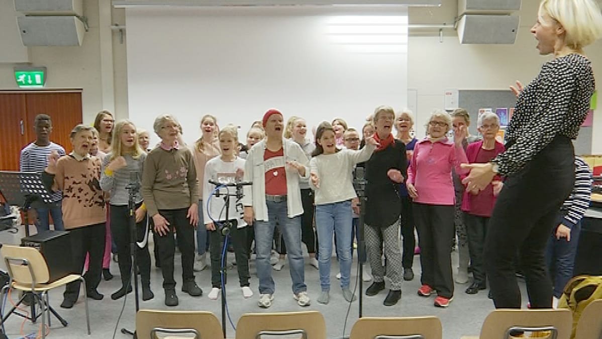Räpätit-kuoro ja Lotilan koulun 6B -musiikkiluokka harjoittelevat. Yhteisömuusikko Laura Kaartinen johtaa.