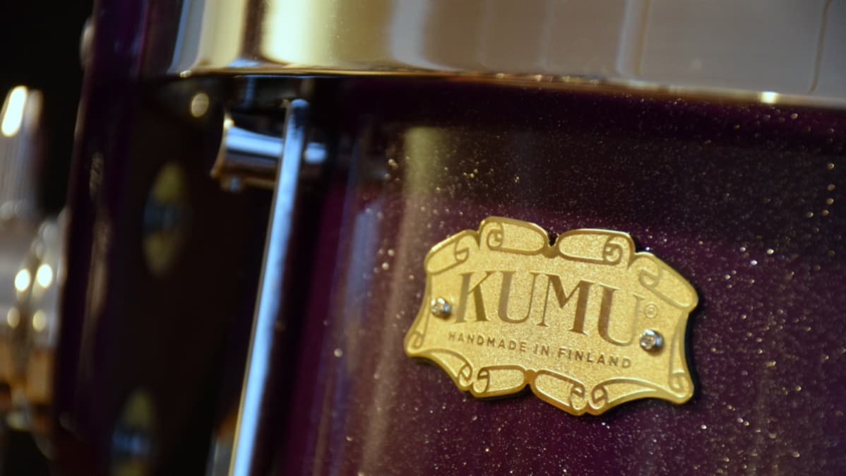 Metallinen lätkä rummun kyljessä jossa lukee Kumu