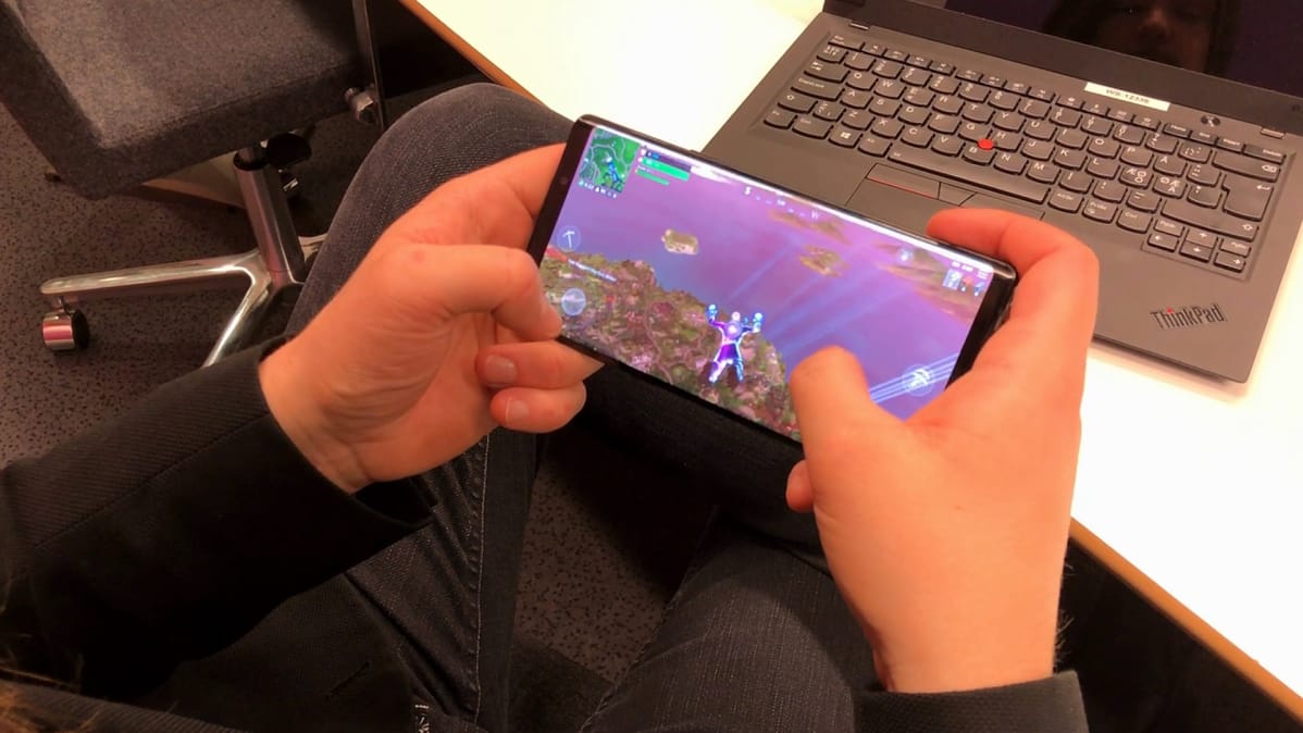 Kuvassa mies pelaa kännykällä Fortniteä