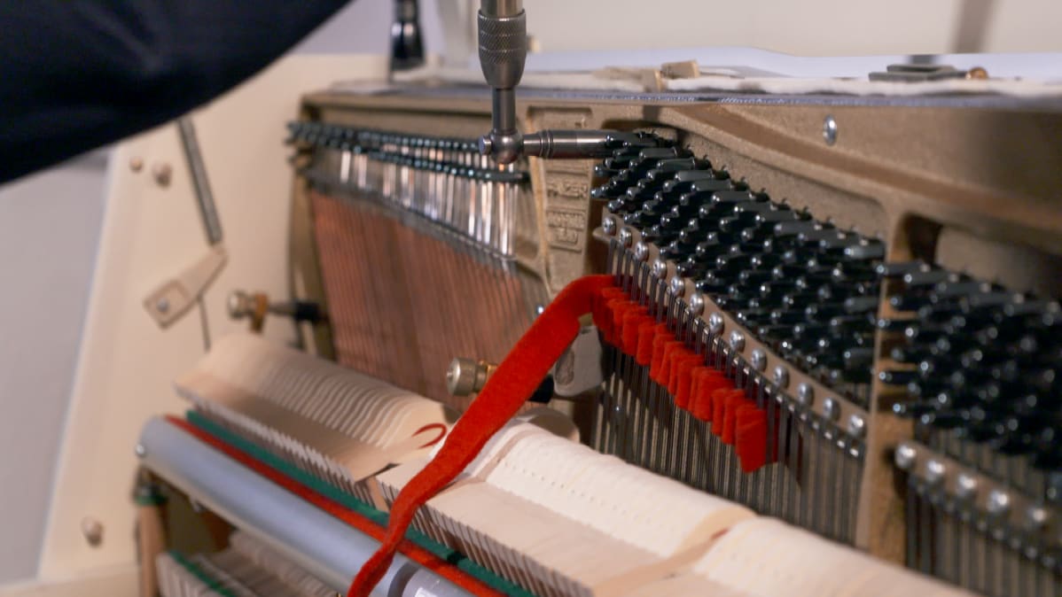 Pianonvirittäjä Pekka Savolainen virittää pianoa.
