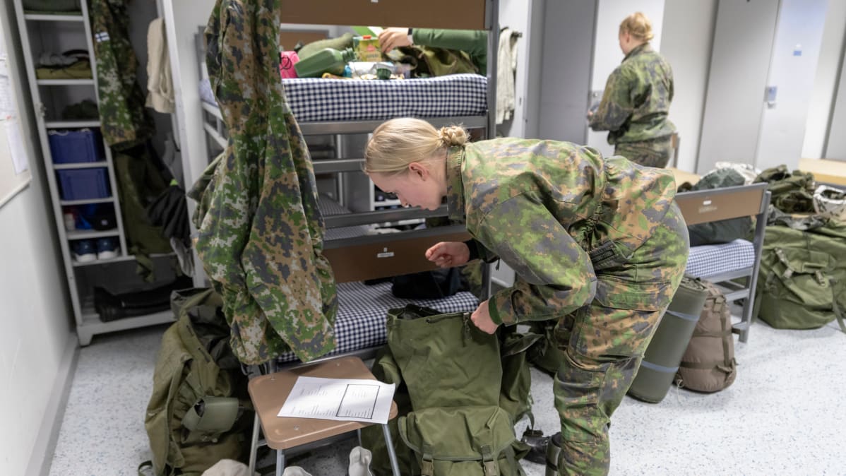Vapaaehtoista asepalvelusta suorittava naisalokas pakkaa tuvassa reppua hiihtomarssia varten