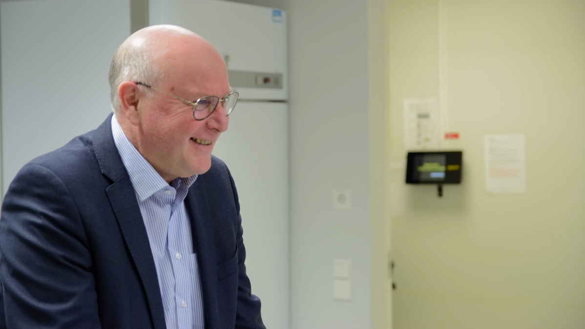 Silmälasipäinen noin 60-vuotias mies katsoo sivukuvassa vasemmalle.