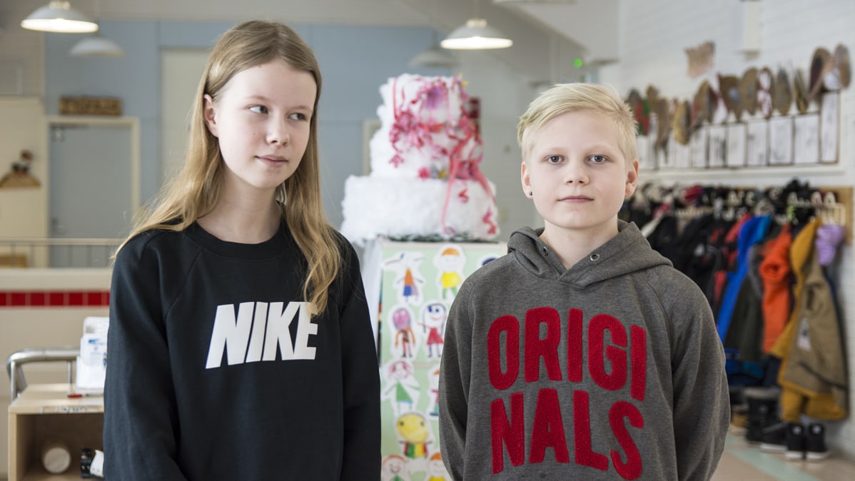 Oppilaat seisovat koulun käytävällä.