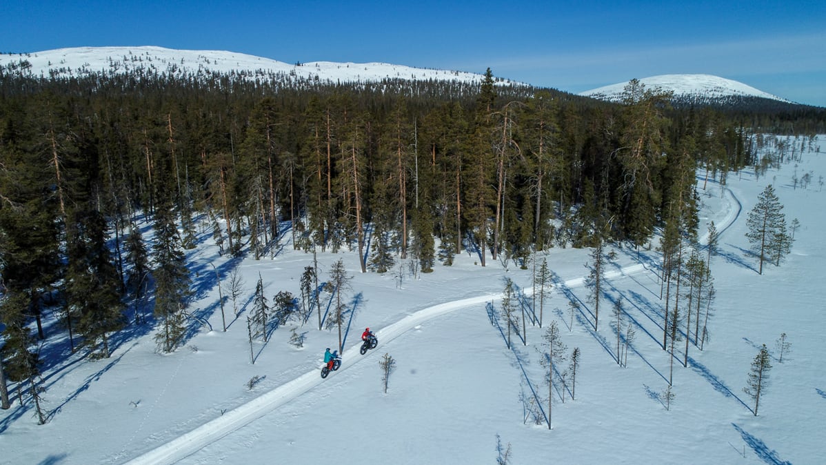 Läskipyöräilijät tunturimaisemassa talvella