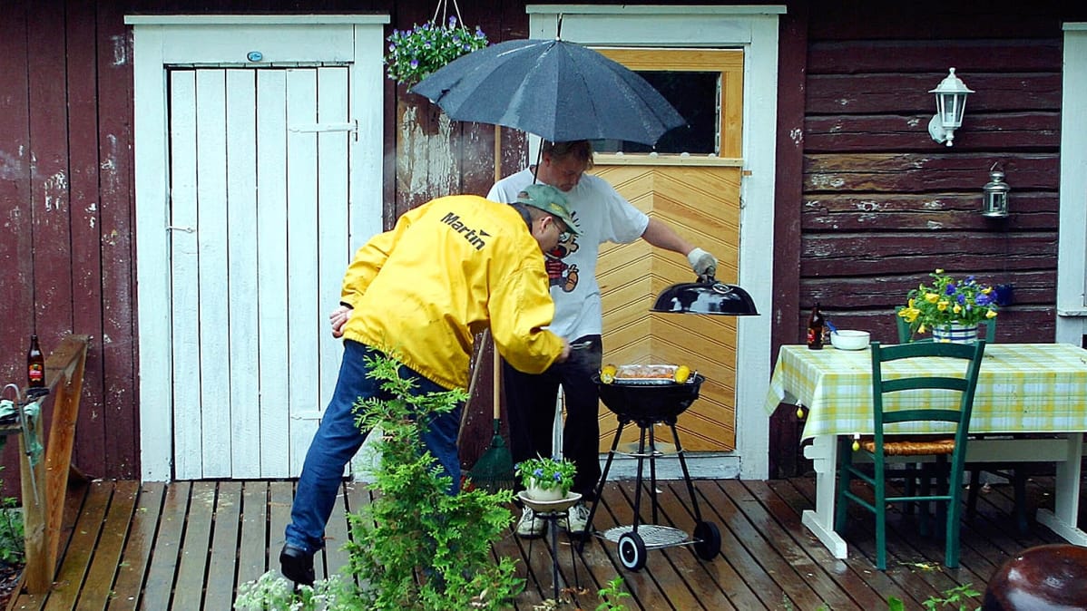 Kaksi miestä grillaa