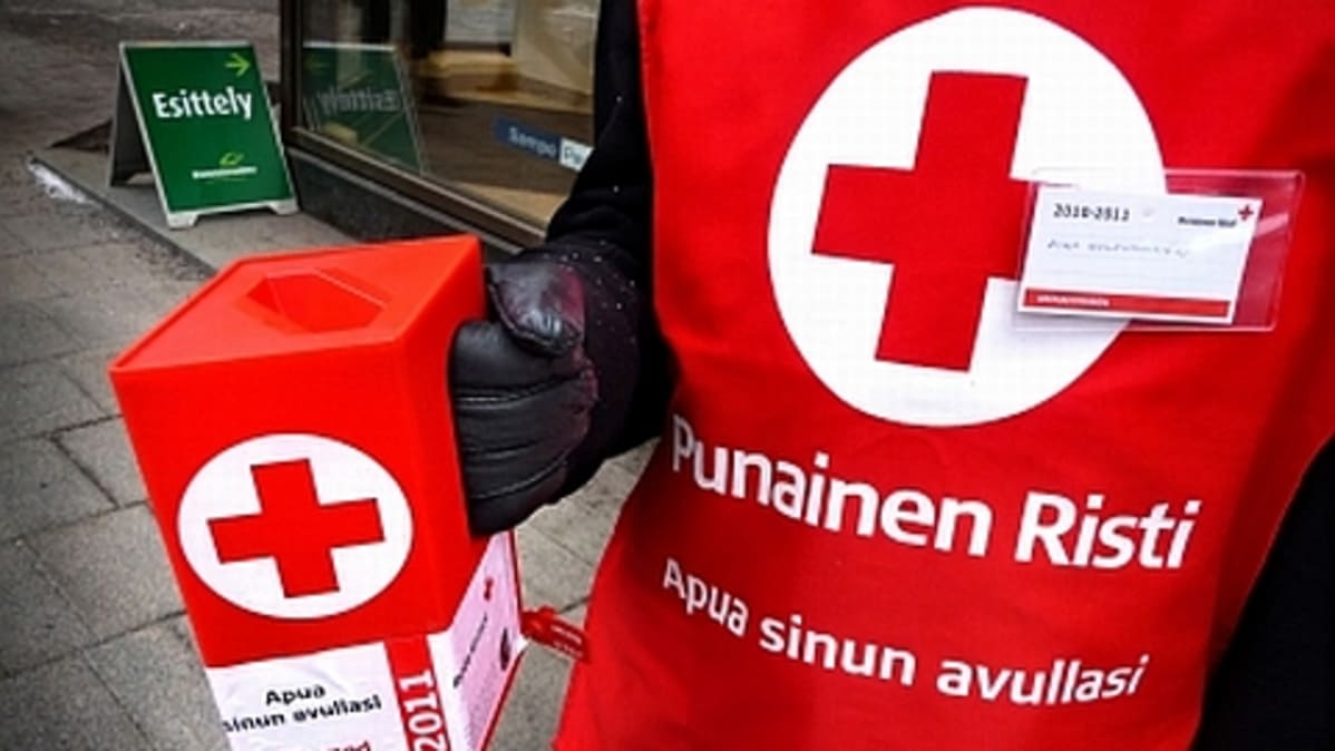Punaisen Ristin kerääjä lippan ja liivin kanssa.