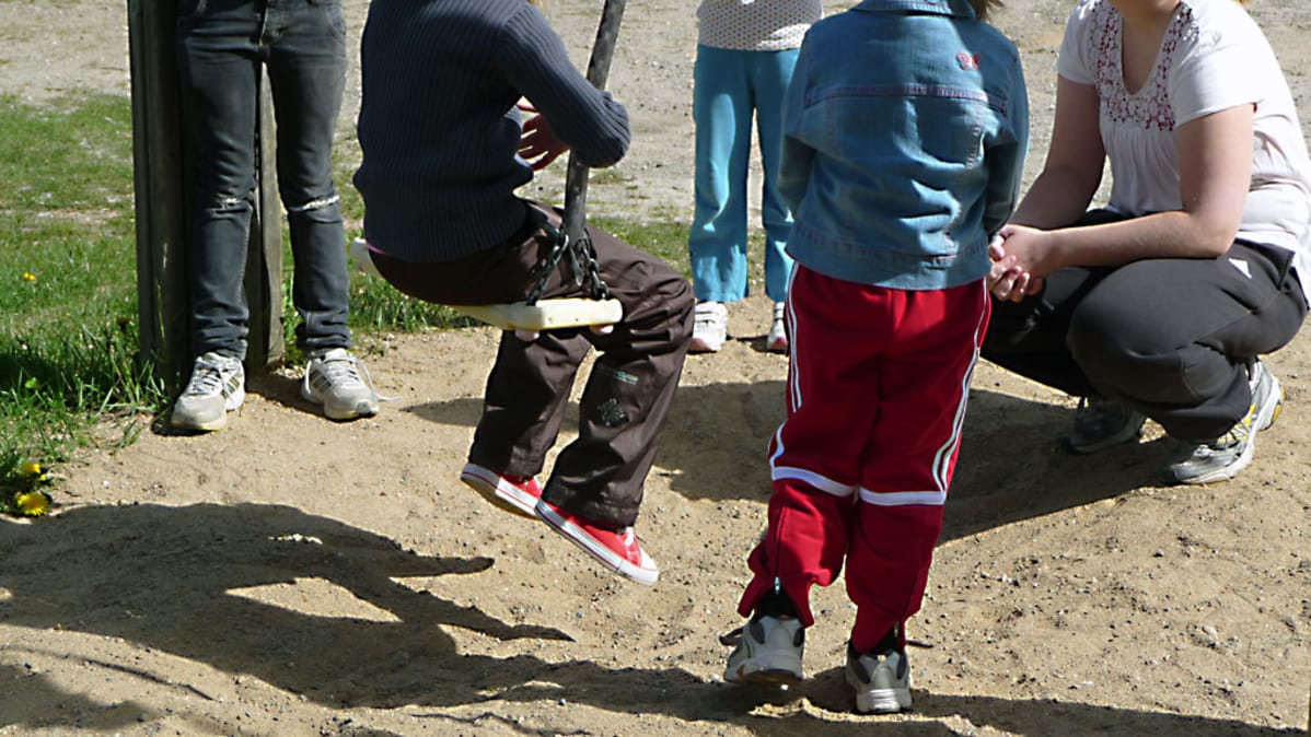 Lapsia ja nuoria pihakeinun luona