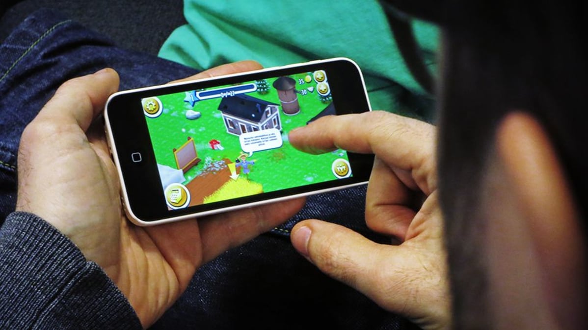 Mies pelaa Hay Day -mobiilipeliä.