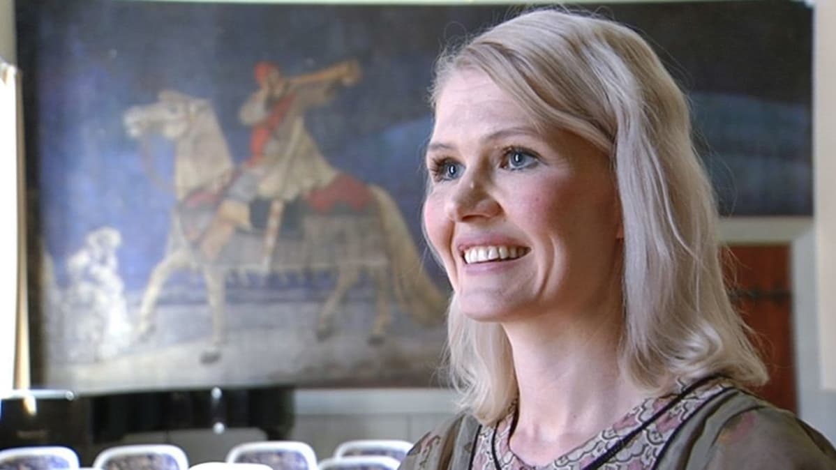 Historioitsija Jenni Kirves ja taustalla Akseli Gallen-Kallelan Kullervon sotaan lähtö -maalaus.