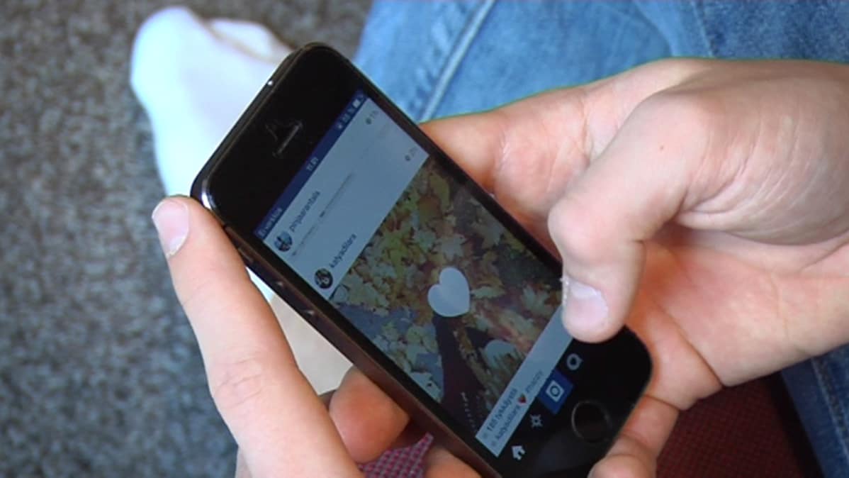 Nuori selaa älypuhelimella Instagramia.