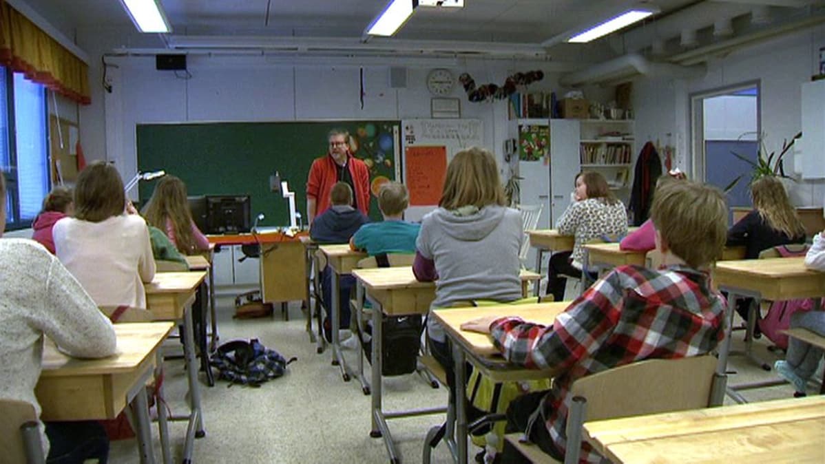 Oppilaita ja opettaja Viljakkalan koulun luokkahuoneessa