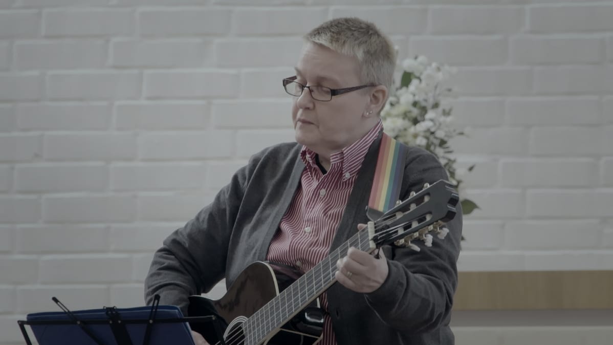 Tarja Pyykkö soittaa kitaraa Sateenkaarimessussa Alppilan kirkossa