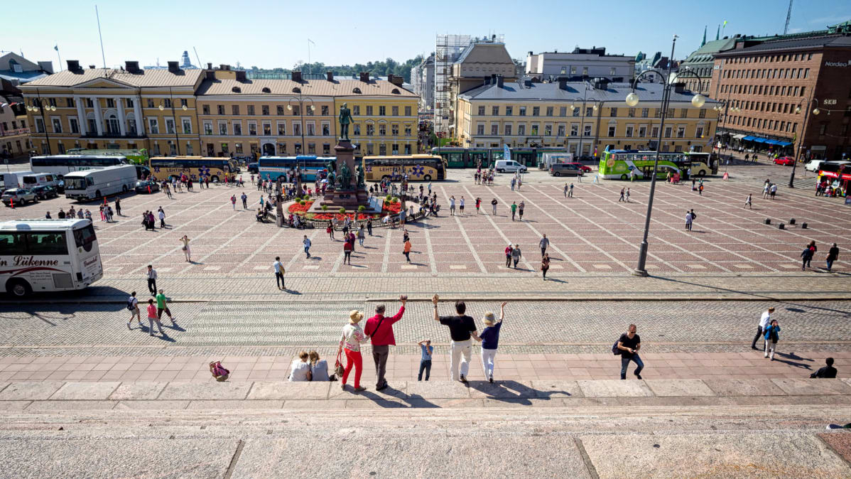 Turistit ottavat ryhmäkuvaa tuomiokirkon portailla.