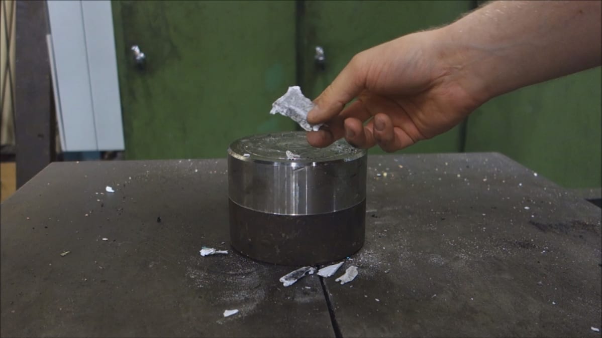 Maailmanmaine aukesi tällä videolla. Taitellusta paperiarkista jäi jäljelle vain murusia hydraulipuristimen käsittelyssä.