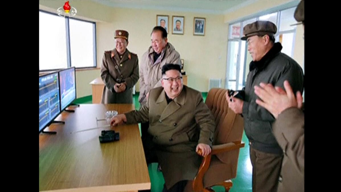 Kim Jong-un hymyilee kuvassa seuratessaan väitettyä rakettimoottorin testausta.