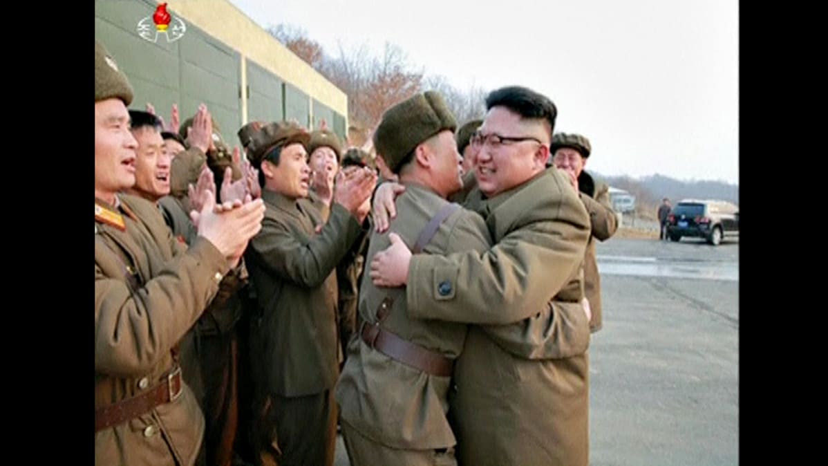 Pohjois-Korean johtaja Kim Jong-un halaa sotilasta. Ympärillä olevat sotilaat osoittavat suosiotaan.
