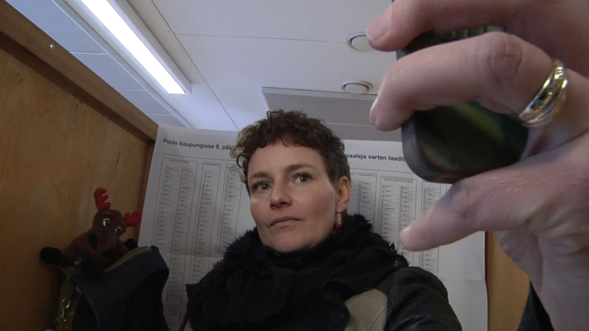 Nainen ottaa valokuvaa itsestään äänestyskopissa.