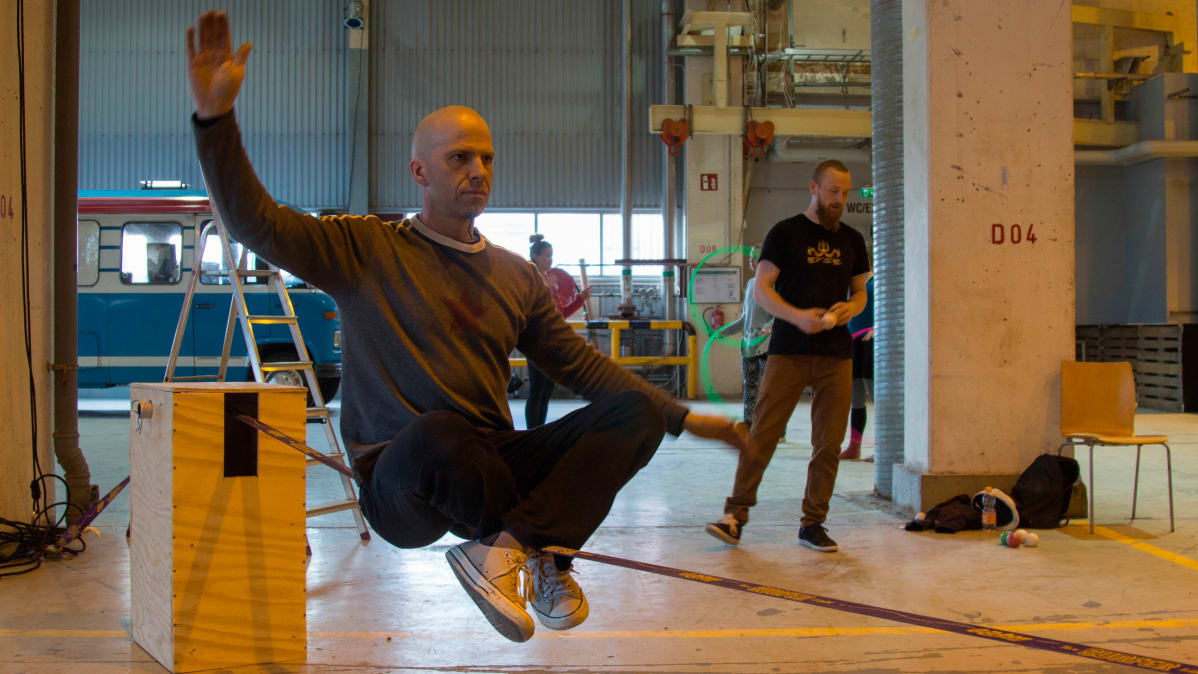 Mies tasapainoilee slacklinellä