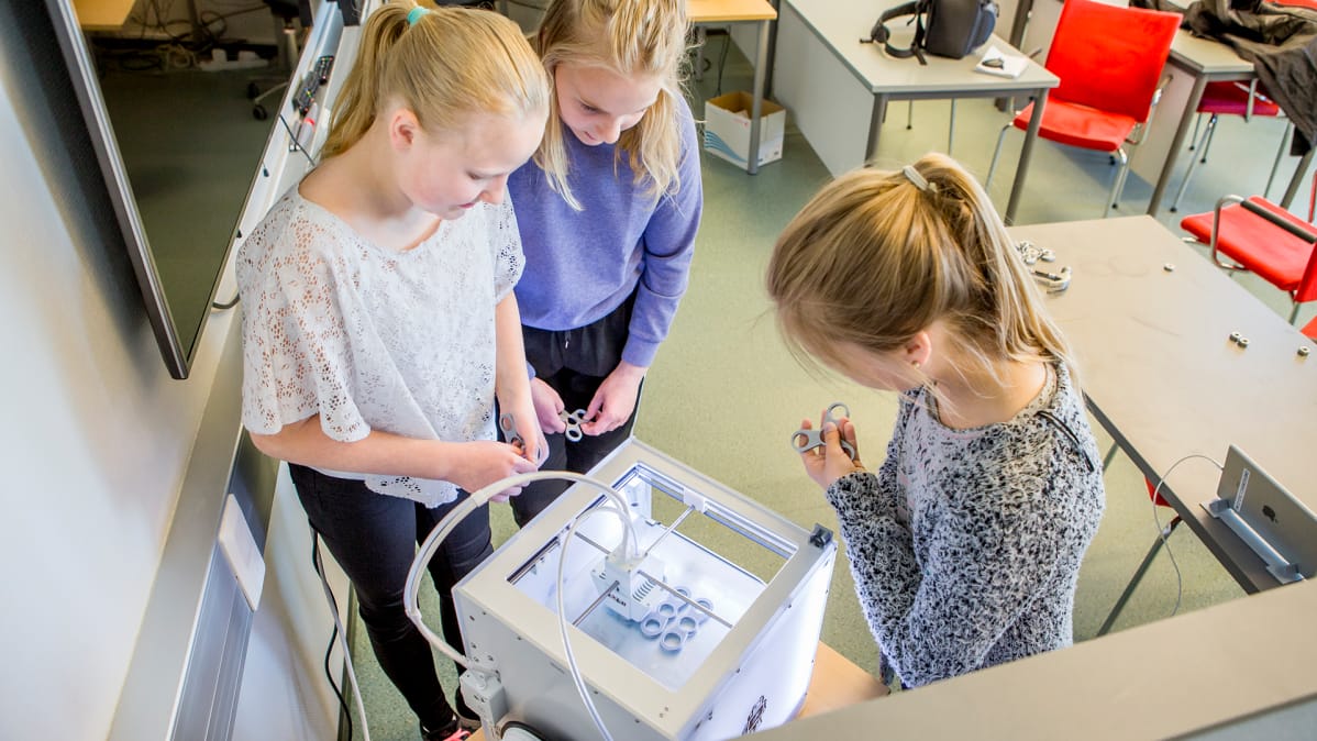 Tytöt katselevat 3D-tulostimen toimintaa