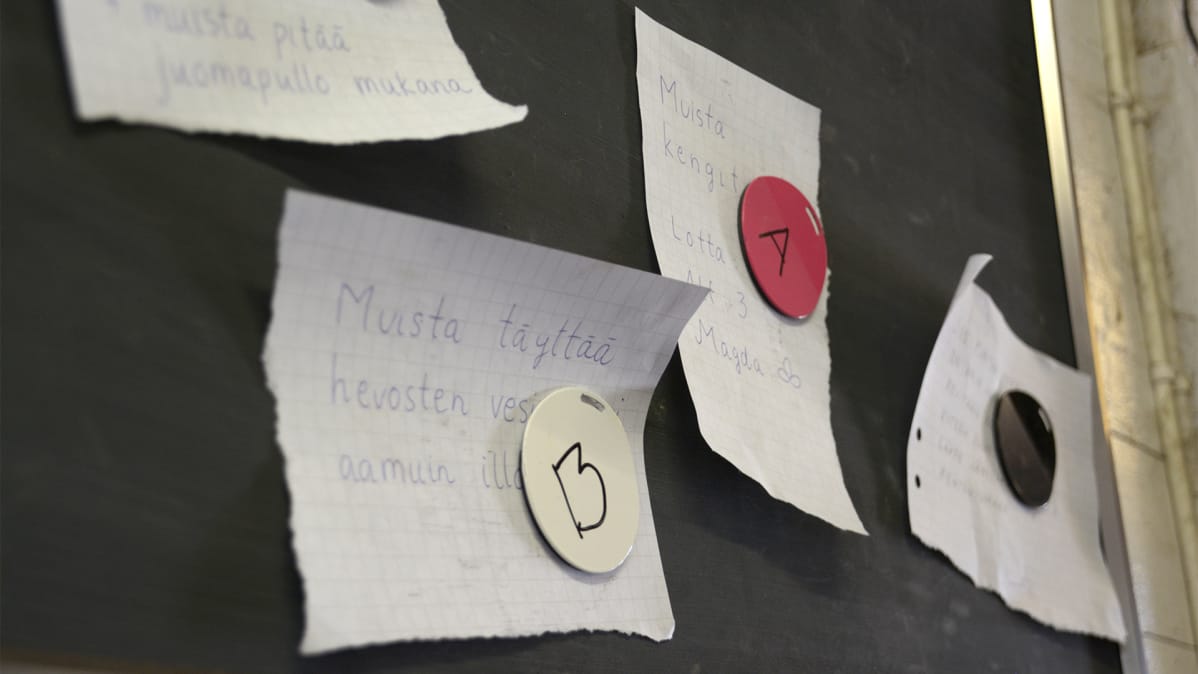 Ilmoitustaululla on magneetilla kiinni paperilappuja joissa on tekstiä