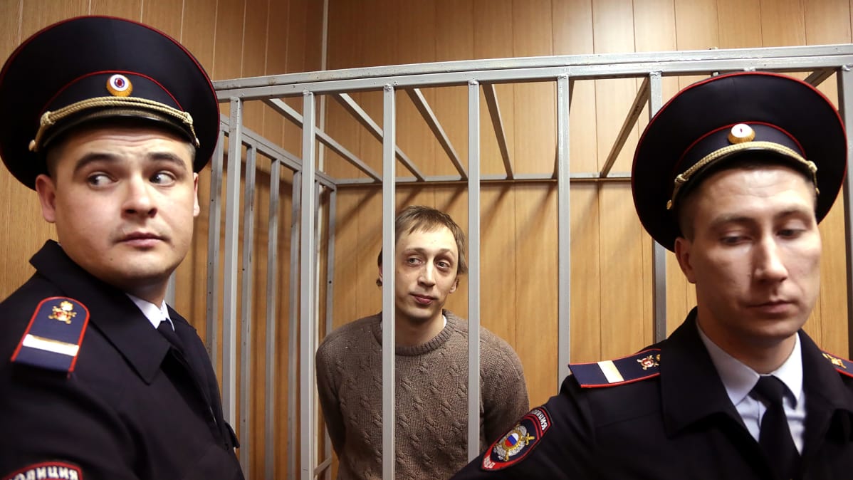 Pavel Dmitrichenko häkissä poliisien vartioimana.