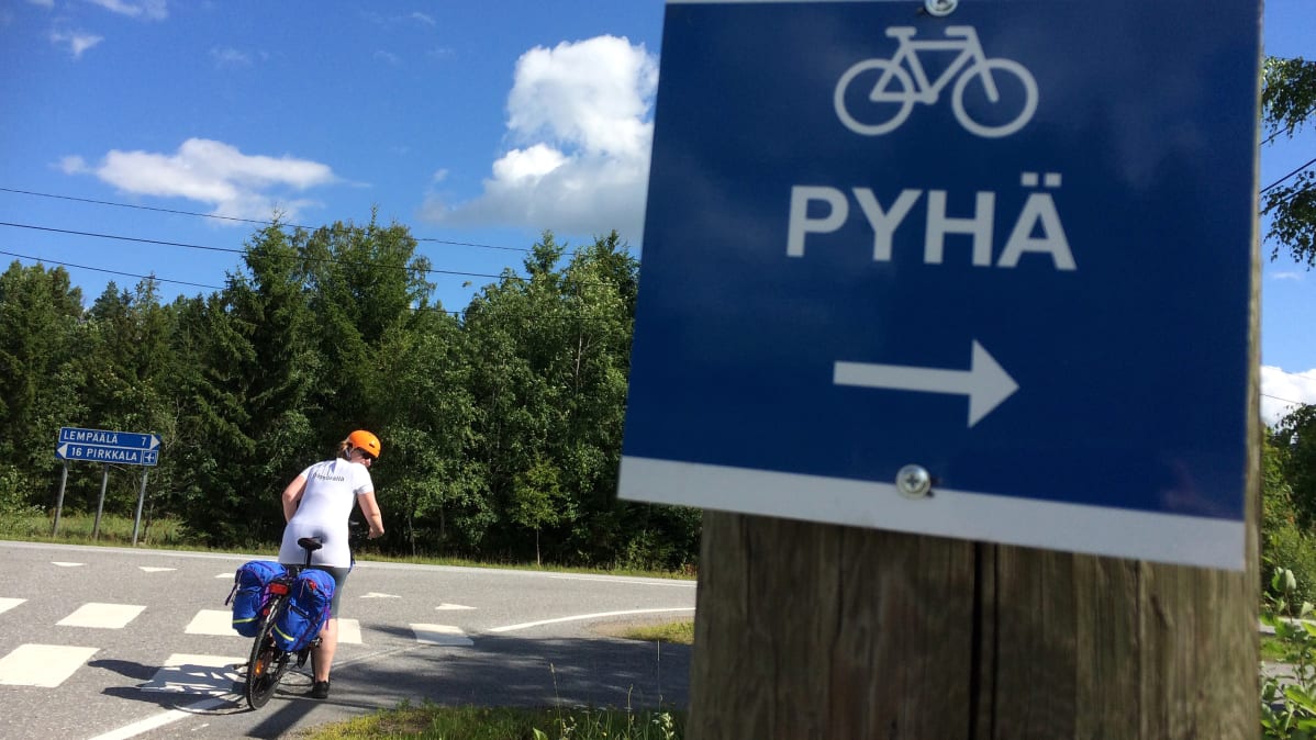 Pyöräilijä pysähtyneenä risteykseen pyöräreitillä